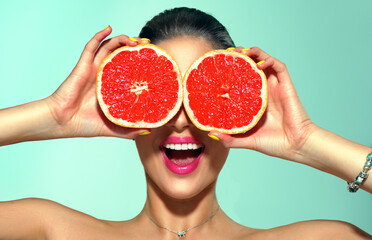 Healthy eating, diet. Beautiful healthy model girl with slices of red grapefruit, food, cosmetics concept. Beauty young fashion woman holding grapefruits, organic vegetables. Vegetarian 