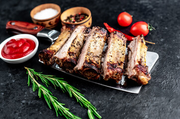 grilled chopped pork ribs on a knife on a stone background