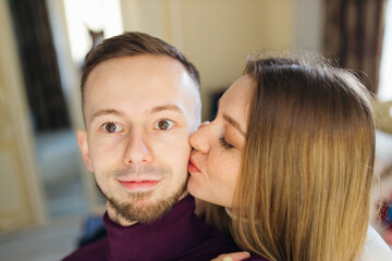 Naklejka premium Smiling caucasian couple standing in their living room at home t