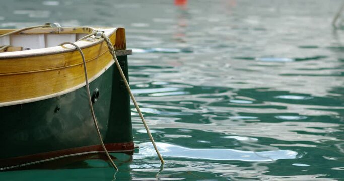 Boats moor in a harbor. We can see a forest in the background near the quay - Red camera 4K