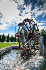 Decorative garden pond with with jugs on a movable wheel on an electric motor. Vertical. copy space