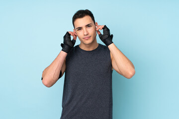 Young sport man over isolated on blue background listening music