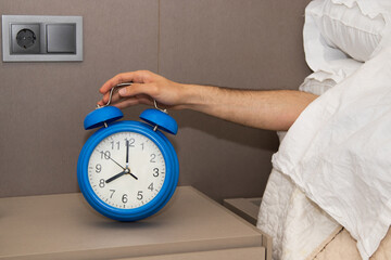hand with alarm clock in the morning