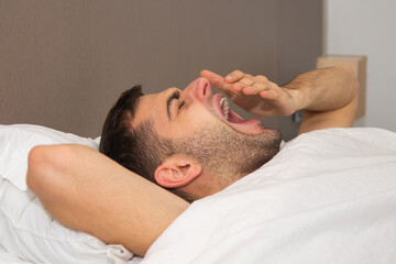 Fototapeta na wymiar man yawning in bed sleepy