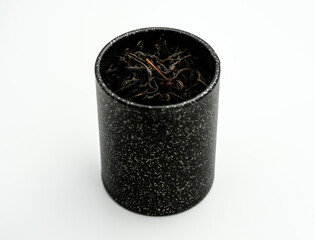 Fototapeta na wymiar black metal box with black tea leaves
