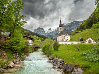 Fototapeta na wymiar Ramsau Bavarian Church view with a river and the mountain chain at the background