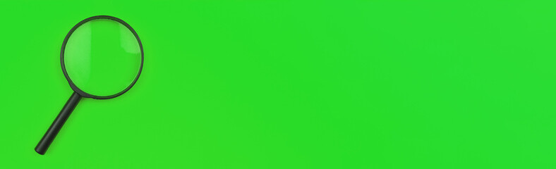Concept of search and question with magnifying glass, banner with green isolated bakcground, copy space and top view photo