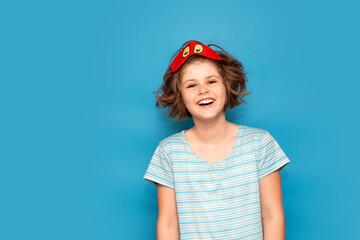 Happy portrait of cute adorable kid. Child girl in mask for sleeping. beautiful girl want to sleep, isolated on blue background. High quality photo