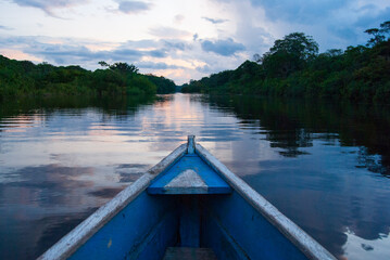 Obraz premium Wooden boat overlooking the sunset or sunrise in the Amazon river