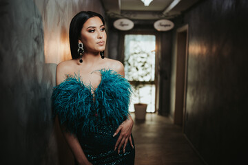 Portrait of a glamorous caucasian female in a luxury evening dress with feathers