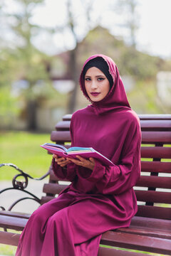 Confident Arab businessman smiling and walks of Dubai. Arab Business vumen hijab is in the streets against the skyscrapers of Dubai. The woman is dressed in a black abaya.
