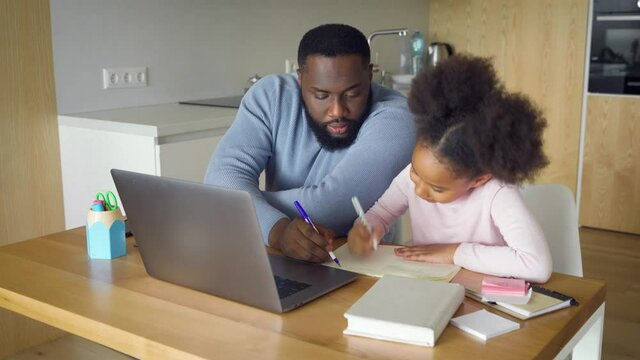 Loving african american father help cute school child daughter study online