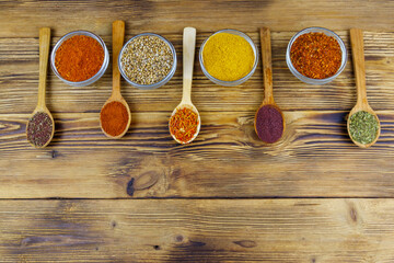 Set of different aromatic spices on wooden table. Top view, copy space