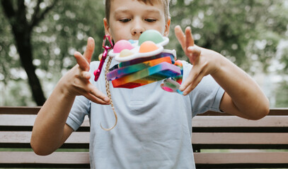 colorful trendy antistress sensory toy fidget push pop it and simple dimple in kid's hands on...