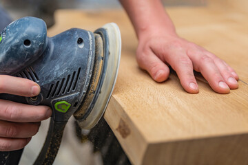A carpenter works in a workshop. Joiner's grinders, furniture manufacturing. A carpenter is...