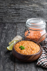 Vegan Red Lentil Soup in wooden bowl on rustic table