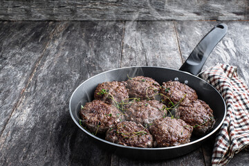 Beef cutlets in a pan on rustic wooden table