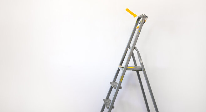 interior of an empty room with a ladder and paint brush