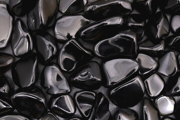 Obsidian heap jewel stones texture on black background