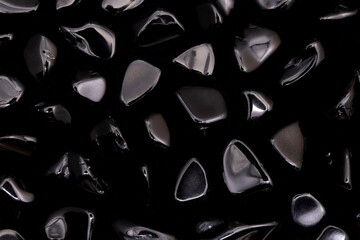 Obsidian rare jewel stones texture on black background