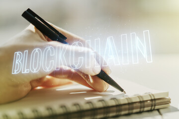Creative abstract blockchain technology sketch and woman hand writing in diary on background, future technology and blockchain concept. Double exposure