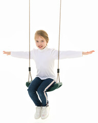 Beautiful teen school girl swinging on a swing. Concept summer vacation.