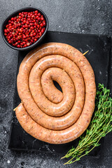 Raw spiral spicy sausage from pork and beef mince meat. Back background. Top view