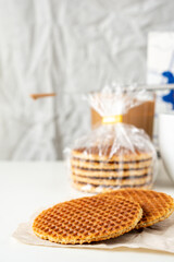 Traditional local authentic Dutch Netherlands sweet fresh homemade tasty stack brown golden waffle melt salted caramel honey syrup for dessert in cafe with hot warm coffee milk tea call Stroopwafel