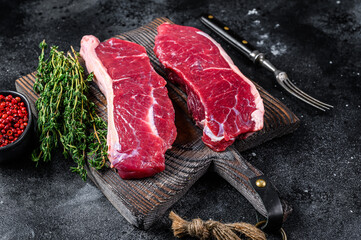 Raw marbled beef meat sirloin steak. Black background. Top view