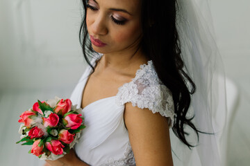 Naklejka premium Happy beautiful bride with her veil smiling and excited in interior, wedding morning