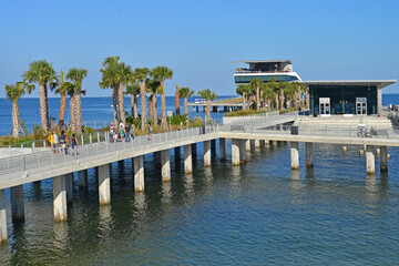 Fototapeta premium The tree lined walkways allow access to the new pier in St Petersburg in Florida. The walk paths along the water are beautiful and picturesque.