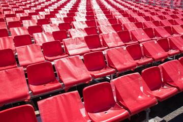 Rows of red plastic seats. Adjacent seats are closed to maintain social distance.