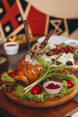 assorted various meat and vegetable dishes laid out on the village board for serving in a restaurant of Ukrainian cuisine