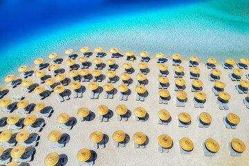 Aerial view of sea, empty sandy beach with sun beds and umbrellas at sunset in summer. Blue lagoon...