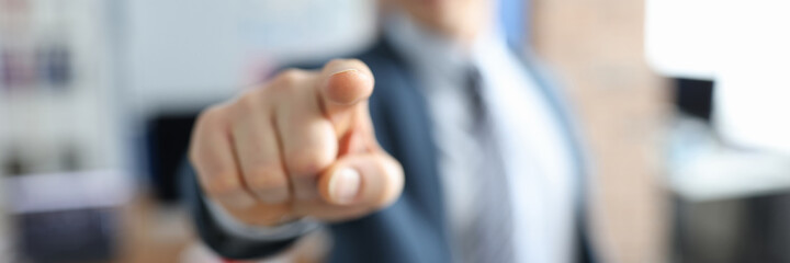 Man in business suit pointing his finger in front of him closeup