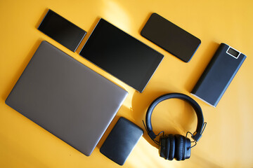 External charger - powerbank, laptop, external hard drive, smartphones and tablet lie on a bright...