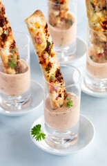 Close up of all in one pizza shot glass appetizers with dipping sauce, ready for eating.