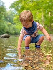 little child playing in the river