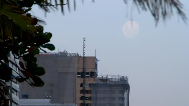 full moon rising seen at ipanema beach in rio de janeiro.