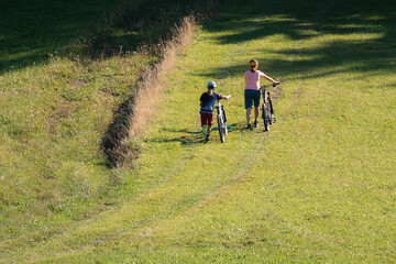 Fototapeta premium Two girls on mtb bikes. Mother and daughter riding on a trail.
