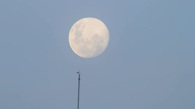 full moon rising seen at ipanema beach in rio de janeiro.