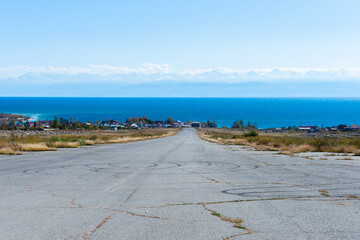 Abandoned airport asphalt runway near Issyk Kul Lake in Kyrgyzstan. View from the airfield runway...