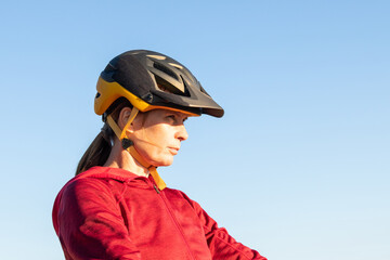 Woman riding mountain bike into the sunset. Beautiful golden summer light.