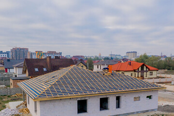 Residential house with wooden roof frame structure under construction. Unfinished brick building...