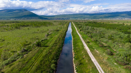 Fototapeta na wymiar Aerial drone view of Irrigation channel in the field. Drainage River channel in nature. 