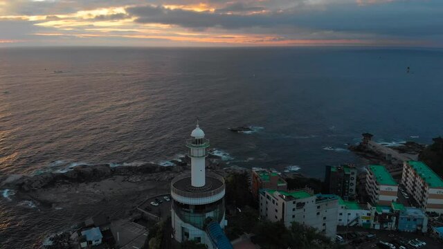 Lighthouse at sunrise of east coast sea of Korea. Sun is gold and clouds are turning golden. Beautiful nature and landmark aerial drone footage took with 4K 30fps.