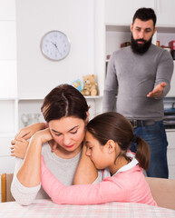 Young father correcting his wife and child for disobedience at home