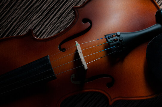 Close up image of Violin on a rustic table in low key light