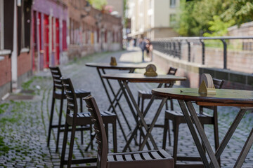 Selective focus at outdoor table and chair without people in front of cafe, bar, and restaurant in walking street old town Düsseldorf, Germany.