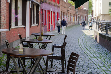 Selective focus at outdoor table and chair without people in front of cafe, bar, and restaurant in walking street old town Düsseldorf, Germany.